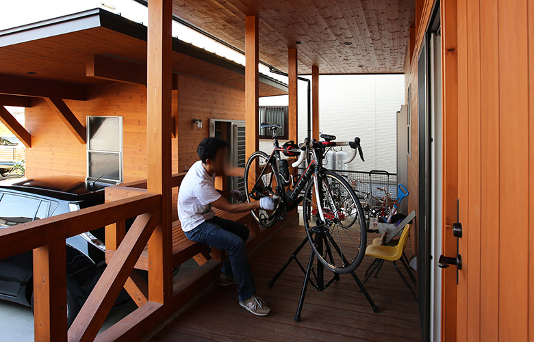 ポーチ部ベンチで自転車整備、奥が外物置