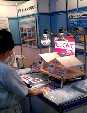 展示の様子。ミラクールと、一般塗料を塗布した屋根材の体感温度を触って比較。